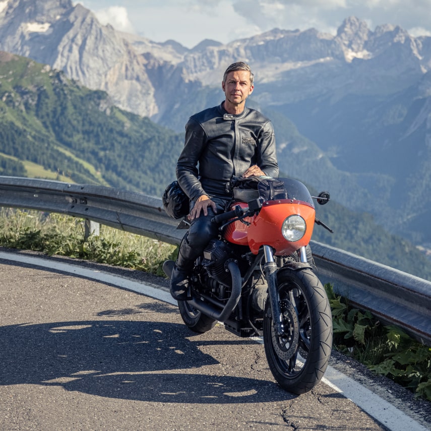 Axel sitting on his red bike in front of the alps